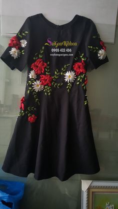 a black dress with red and white flowers on it