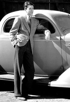 a man leaning on the side of an old car