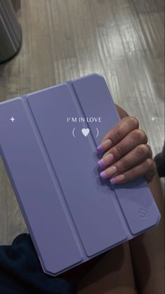 a woman's hand holding an ipad case that says i'm in love