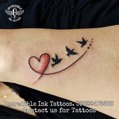 a woman's arm with birds flying in the air and a heart tattoo on it