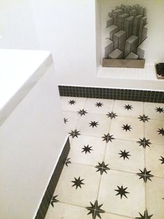 a white toilet sitting next to a sink in a bathroom under a window with black stars on it