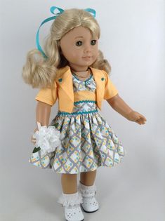 a doll with blonde hair wearing a dress and shoes