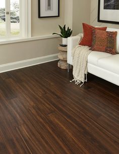 a living room with wood floors and white furniture