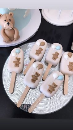 there are many pops with teddy bears on them and some spoons in the shape of toothpicks