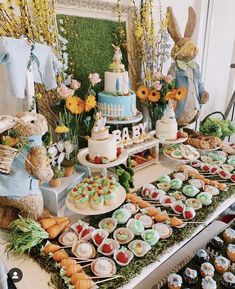 a table filled with lots of cakes and cupcakes next to bunnies on trays