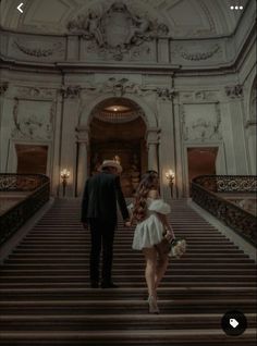 a man and woman are walking down the stairs