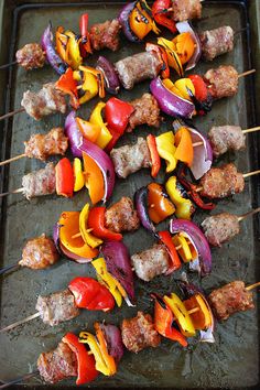 several skewers of meat and vegetables on a grill