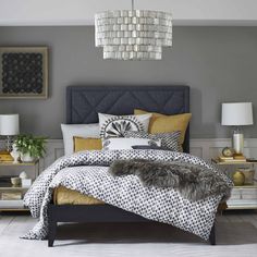 a bedroom with grey walls and white carpeted flooring is decorated in black, gold and white