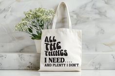 a white tote bag with the words all the things i need and plenty it don't