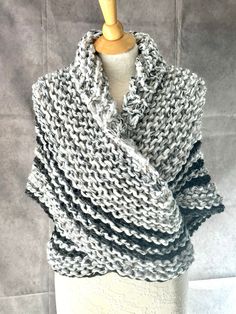 a gray and white knitted scarf on a mannequin