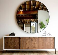 a large round mirror hanging on the side of a wall