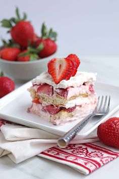 there is a piece of cake with strawberries on the plate and two forks next to it