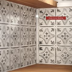 the corner of a kitchen with white tiles and red sign on it's wall