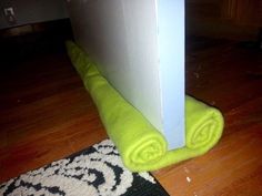 a green towel sitting on top of a wooden floor next to a white door frame