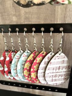 six key chains hanging from hooks on a rack with music notes and christmas ornaments in the background