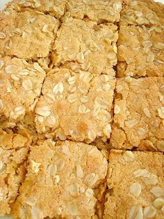 a white plate topped with lots of oatmeal squares on top of a table