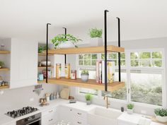 a kitchen filled with lots of white counter tops and wooden shelves above the stove top