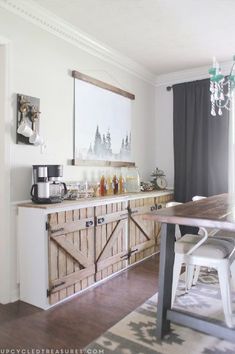 a dining room table with chairs and a large painting hanging on the wall above it