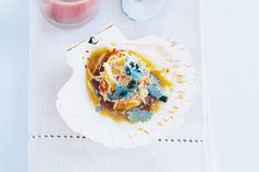 a white plate topped with food on top of a table next to a glass of juice