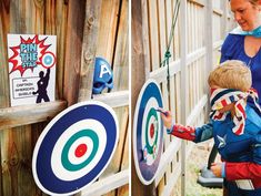 a woman and child are playing with some archery target magnets on a fence post