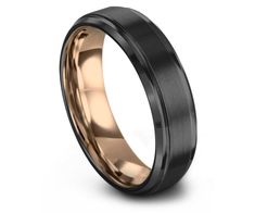 the black and rose gold wedding band is shown from the side, with an elegant design