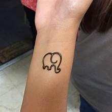 an elephant tattoo on the wrist of a woman