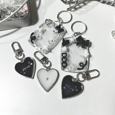 several key chains with charms attached to them on a white counter top next to a cell phone