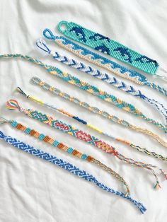 six bracelets are lined up on a white sheet