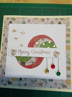 a christmas card with ornaments hanging from it