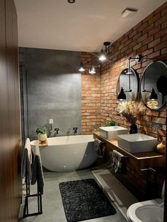 a modern bathroom with brick walls and an oval bathtub in the middle, along with two sinks