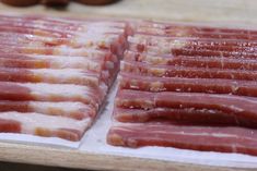 bacon strips are lined up on a cutting board