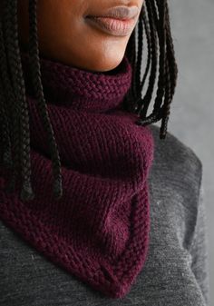 a woman with dreadlocks wearing a purple knitted cowl neckwarf