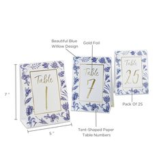 the table numbers and place cards are labeled in gold foil on blue floral paper, along with matching envelopes