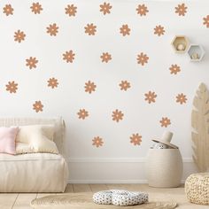 a living room with white walls and brown flowers on the wall, along with a beige couch