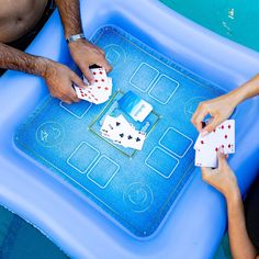 two people playing cards on an inflatable pool