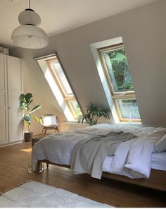 a bedroom with two windows and a bed in it