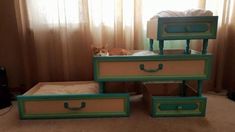 three drawers stacked on top of each other with a cat laying in the bottom drawer