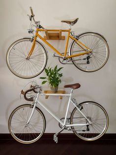 a bike mounted to the side of a wall next to a potted green plant