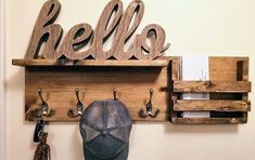 there is a hat and hooks on the wall next to a sign that says hello