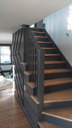 a stair case in the middle of a room with hardwood floors and blue painted walls