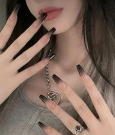 a woman with black nails and rings on her fingers