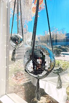 two disco ball hanging from the side of a window