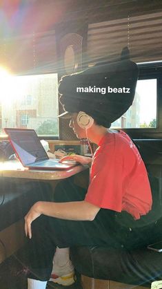 a man sitting at a desk with a laptop computer on his head and the words making beatz above him