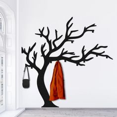 a coat rack is hanging on the wall next to a tree with an orange towel