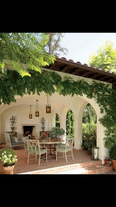 an outdoor dining area with patio furniture and potted plants on the side of it