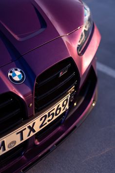 the front end of a purple sports car with chrome lettering on it's bumper