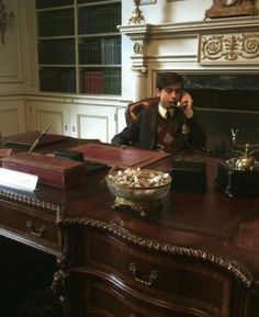 a man sitting at a desk talking on the phone