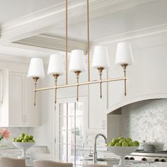 a large kitchen with white cabinets and marble counter tops, along with an island in the middle