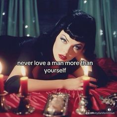 a woman laying on top of a bed with candles in front of her and the words never love a man more than yourself