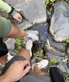 two people standing next to each other on rocks